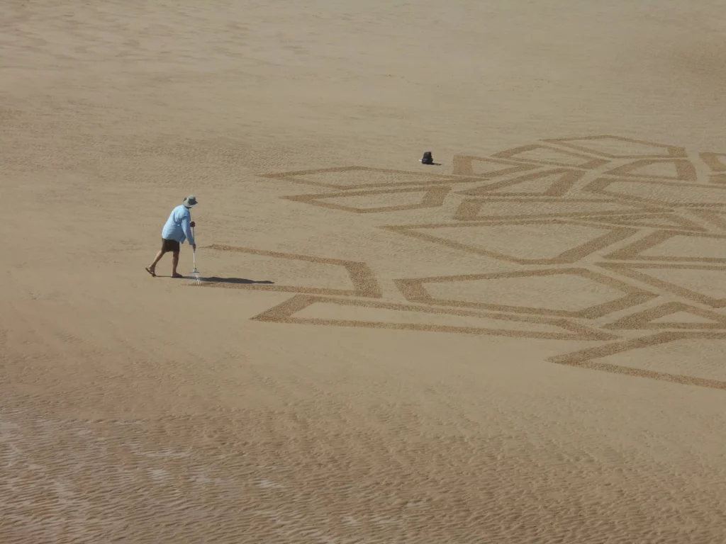 homme qui dessine dans le sable