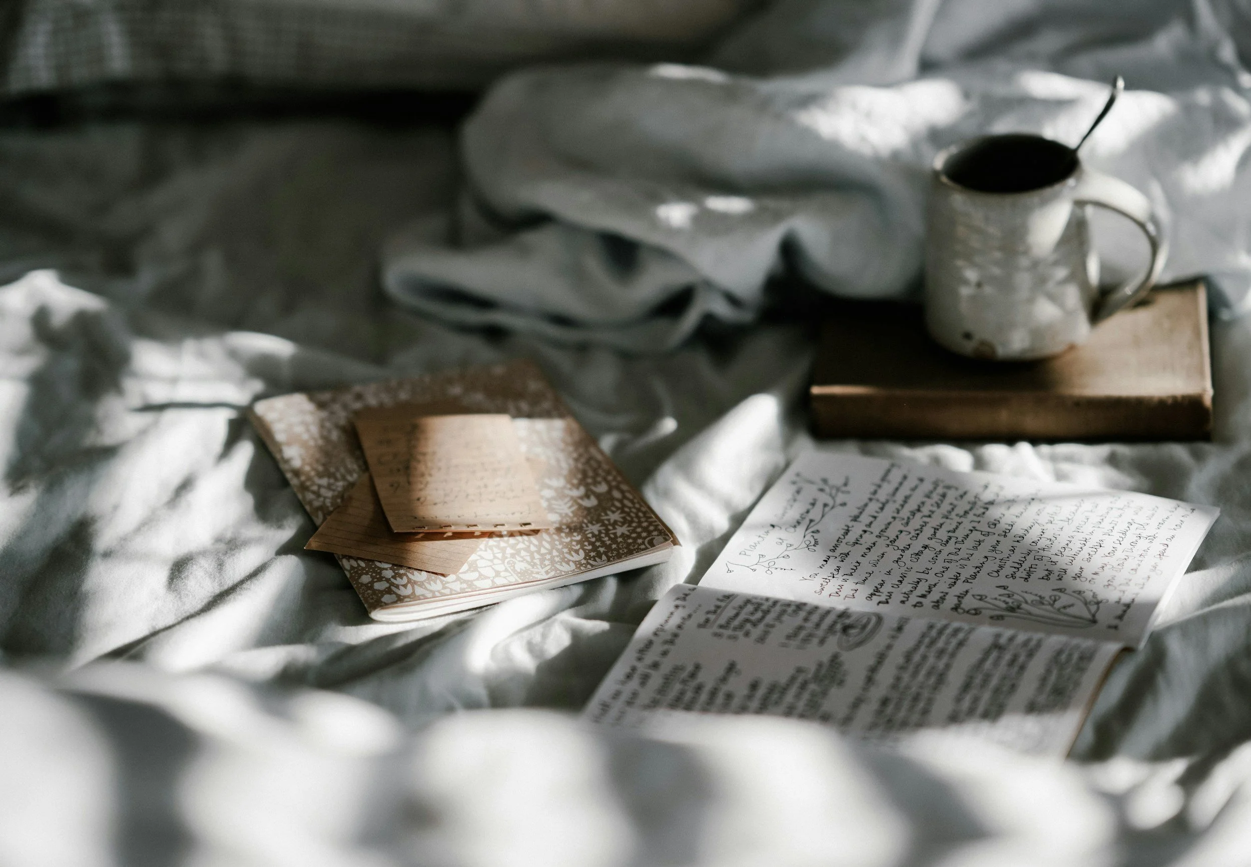carnet et tasse sur un lit