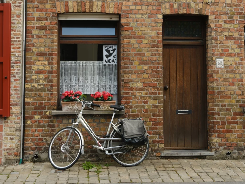 un vélo posé devant une maison typique de Bruges
