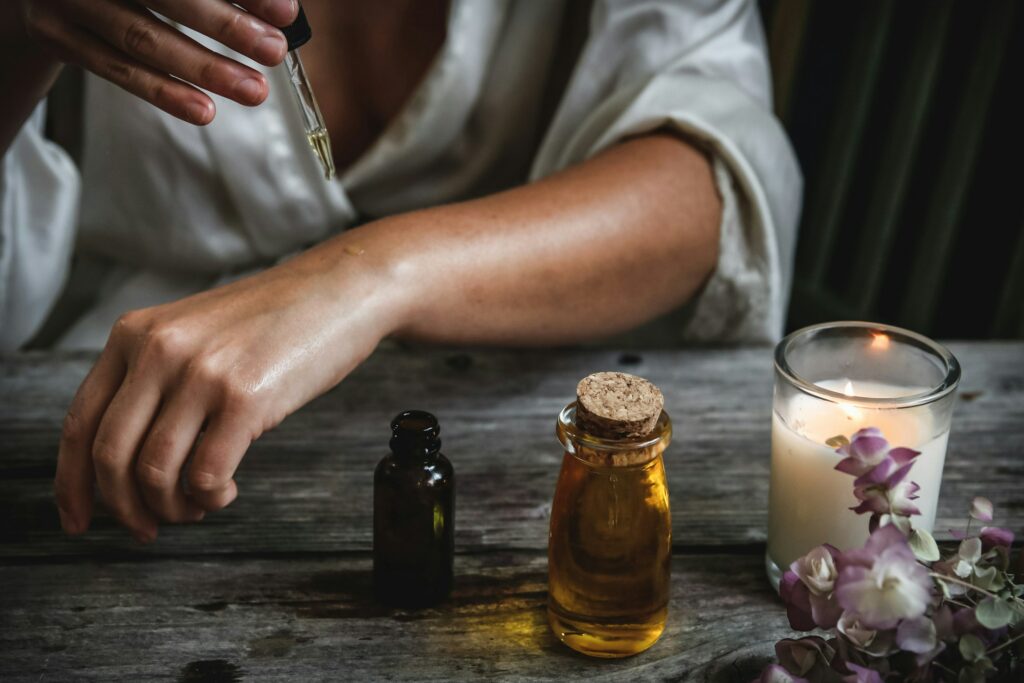 bras de femme qui s'applique des huiles beauté