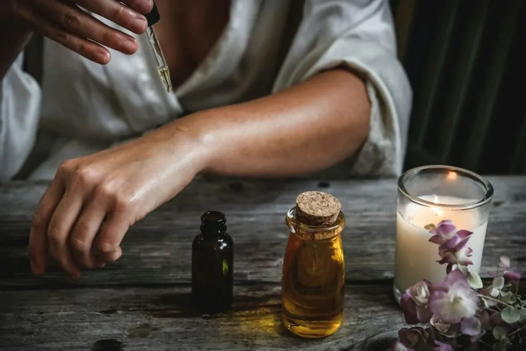 bras de femme qui s'applique des huiles beauté