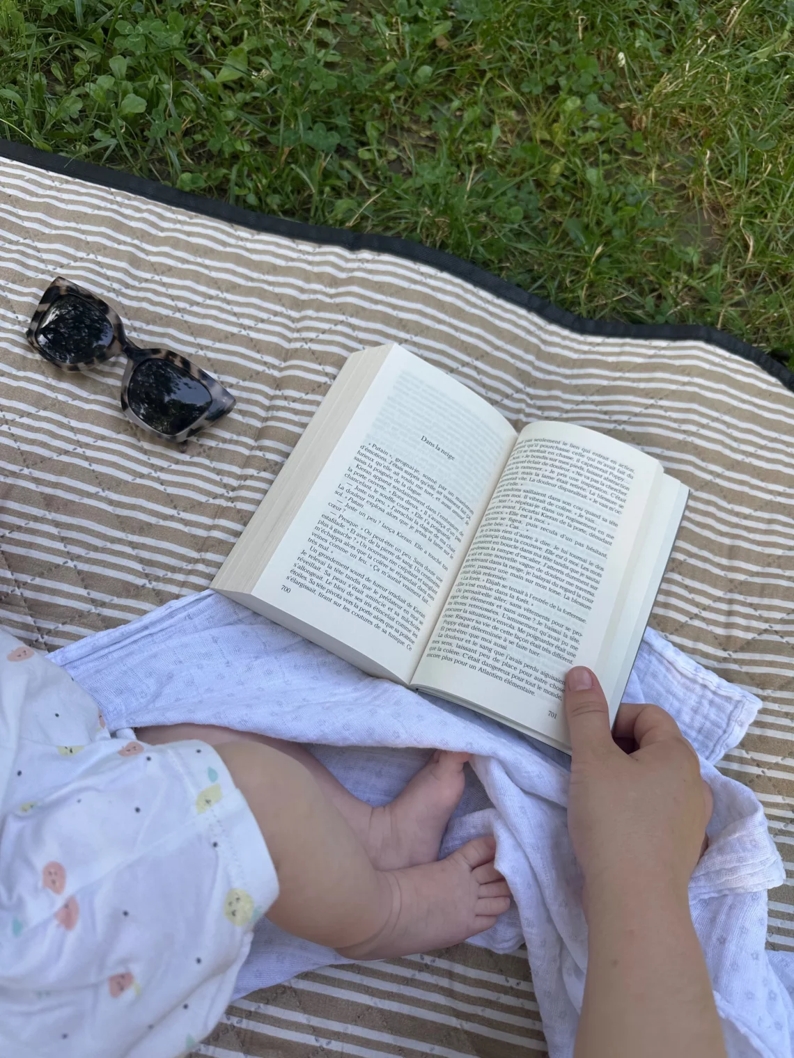 livre ouvert sur une couverture posée dansl' herbe