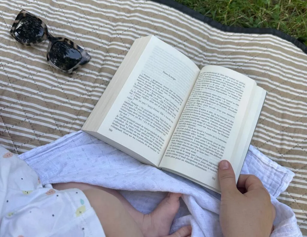 livre ouvert sur une couverture posée dansl' herbe
